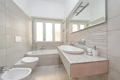 a bathroom with two sinks and a toilet and a tub at New Apartment with balcony - 150m Metro A in Rome