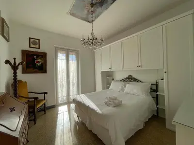 a bedroom with a white bed and a chandelier at Mazzoni Suite, Panoramic Terrace and Comfort in Rome