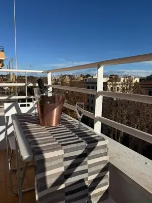 a table with a wine glass and a bucket on a balcony at Piramide Cestia Apartment in Rome