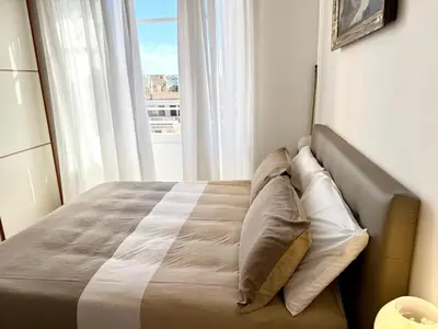 a bedroom with a bed with a large window at Piramide Cestia Apartment in Rome