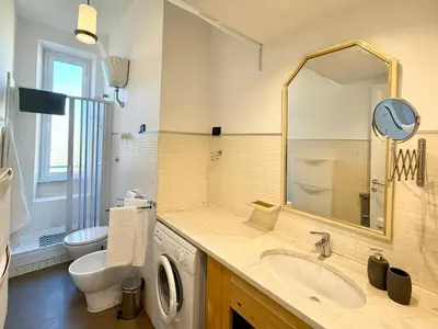 a bathroom with a sink and a toilet and a mirror at Piramide Cestia Apartment in Rome