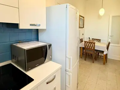a kitchen with a white refrigerator and a table at Piramide Cestia Apartment in Rome