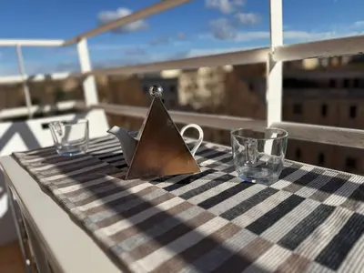 a table with a napkin and glasses on a balcony at Piramide Cestia Apartment in Rome