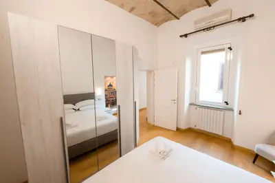 a bedroom with a bed and a mirror at Amor Guest House San Giovanni in Rome