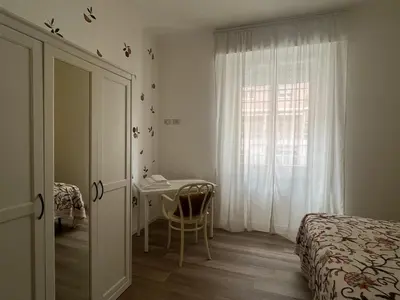 a bedroom with a bed and a desk and a window at Casa Giovi in Rome