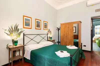 a bedroom with a bed with a green blanket at Silenzioso, grande, comodo alloggio a Trastevere in Rome