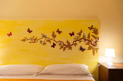 a bedroom with a painting of a branch with butterflies at Silenzioso, grande, comodo alloggio a Trastevere in Rome