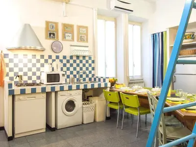 a kitchen with a sink and a table with chairs at Silenzioso, grande, comodo alloggio a Trastevere in Rome