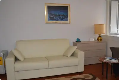 a living room with a white couch and a dresser at Casa in centro storico Largo Argentina in Rome