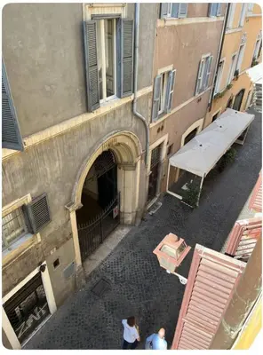 two people standing in an alley next to a building at Casa in centro storico Largo Argentina in Rome