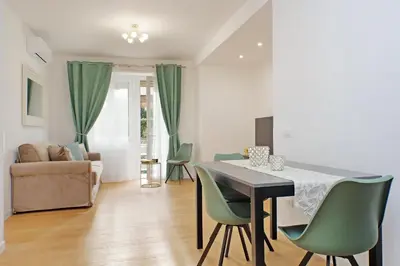 a living room with a table and green chairs at Graceful Apartment near St Peter METRO 100 mt in Rome