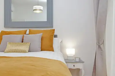a bed with orange and white pillows and a table at Graceful Apartment near St Peter METRO 100 mt in Rome