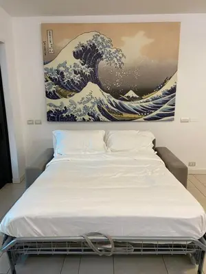 a bed in a room with a painting on the wall at P&P Luxury Home in Rome