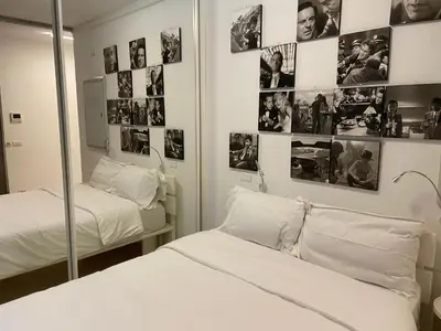 two beds in a room with pictures on the wall at P&P Luxury Home in Rome