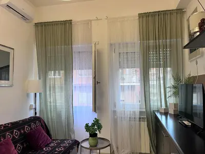 a living room with curtains and a couch and a television at Nido rinnovato in Rome
