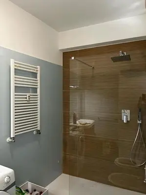 a bathroom with a glass shower with a sink at Nido rinnovato in Rome