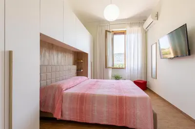 a bedroom with a bed with a pink blanket at Cozy and Bright Pyramid Apartment in Rome