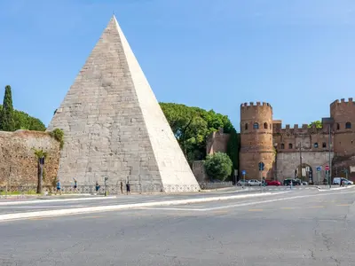 a pyramid in front of a large castle at Cozy and Bright Pyramid Apartment in Rome