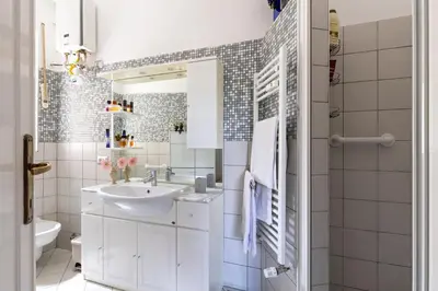 a white bathroom with a sink and a toilet at Cozy and Bright Pyramid Apartment in Rome