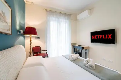 a bedroom with a bed and a tv on a wall at Vatican City Historic Center -Luxury Flat with Garden and Private Parking in Rome