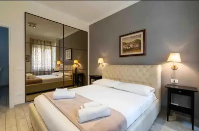 a bedroom with a large white bed with a large mirror at Vatican City Historic Center -Luxury Flat with Garden and Private Parking in Rome