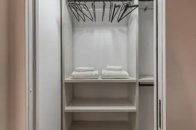 a closet with white shelves and towels in it at La Casa Dei Sogni in Rome