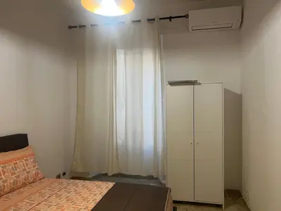 a bedroom with a bed and a white cabinet at Rosa di San Giovanni in Rome