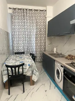 a kitchen with a table and a washing machine at Rosa di San Giovanni in Rome
