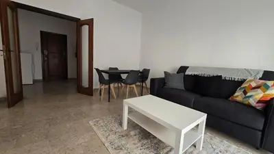 a living room with a black couch and a table at Ferrari House in Rome