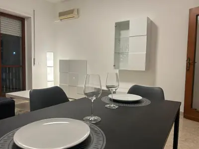 a table with two wine glasses and plates on it at Ferrari House in Rome