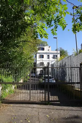 a gate in front of a house with a building at Domus Roma G&R in Rome