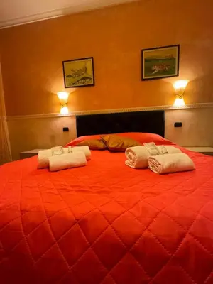 a red bed with two towels on top of it at Tatyana appartament in Rome