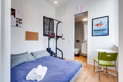 a bedroom with a blue bed and a green chair at Modern flat in Vatican in Rome