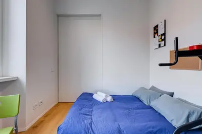 a bedroom with a bed with a blue comforter at Modern flat in Vatican in Rome