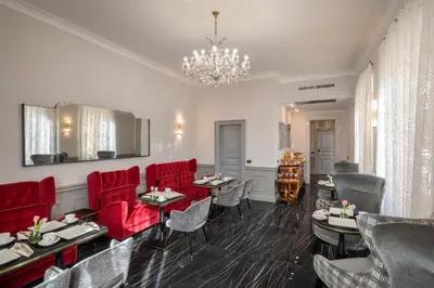 a dining room with red chairs and a chandelier at The Inn at the Spanish Steps Elegant Collection - The Gem in Rome