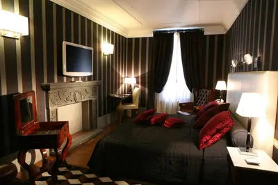 a bedroom with a bed and a fireplace and a television at The Inn at the Spanish Steps Elegant Collection - GioielloJewel in Rome