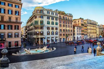 a group of buildings in a street with a fountain at The Inn at the Spanish Steps Elegant Collection - GioielloJewel in Rome