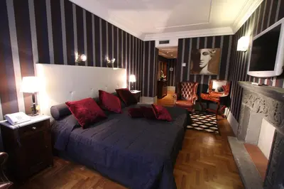 a bedroom with a large bed with red pillows at The Inn at the Spanish Steps Elegant Collection - GioielloJewel in Rome