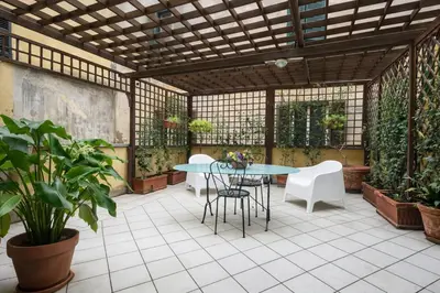a patio with a table and chairs and plants at Love Roma Termini Apartment with Terrace in Rome