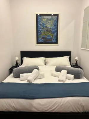 a large white bed with pillows and a painting at Love Roma Termini Apartment with Terrace in Rome