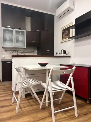 a kitchen with a white table and two stools at Love Roma Termini Apartment with Terrace in Rome