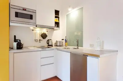 a white kitchen with a sink and a microwave at Rome as you feel - Baullari with terrace in Rome