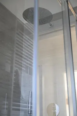a shower with a glass door with a fan at Alloggio per uso turistico Roma Casal Bertone - Casa del Sole in Rome