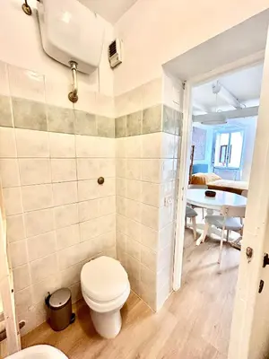 a bathroom with a toilet and a table at Colosseo Lovely studio apartment in Rome