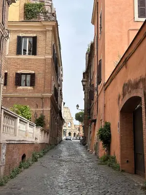 an empty street in an alley between two buildings at Colosseo Lovely studio apartment in Rome