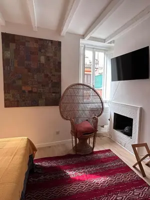 a bedroom with a wicker chair and a fireplace at Colosseo Lovely studio apartment in Rome