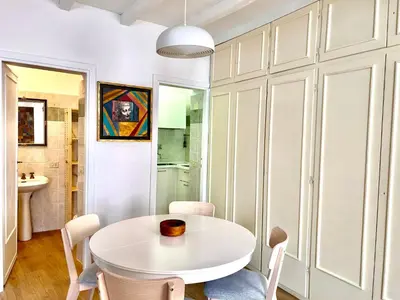 a white dining room with a white table and chairs at Colosseo Lovely studio apartment in Rome