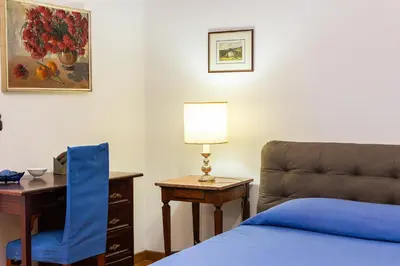 a bedroom with a bed and a desk and a chair at Amazing San Giovanni in Laterano in Rome