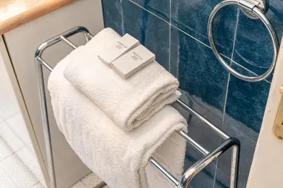 a towel rack in a bathroom with white towels at Amazing San Giovanni in Laterano in Rome