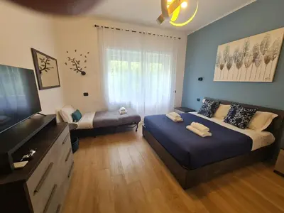 a bedroom with two beds and a flat screen tv at La casa di Ricky in Rome